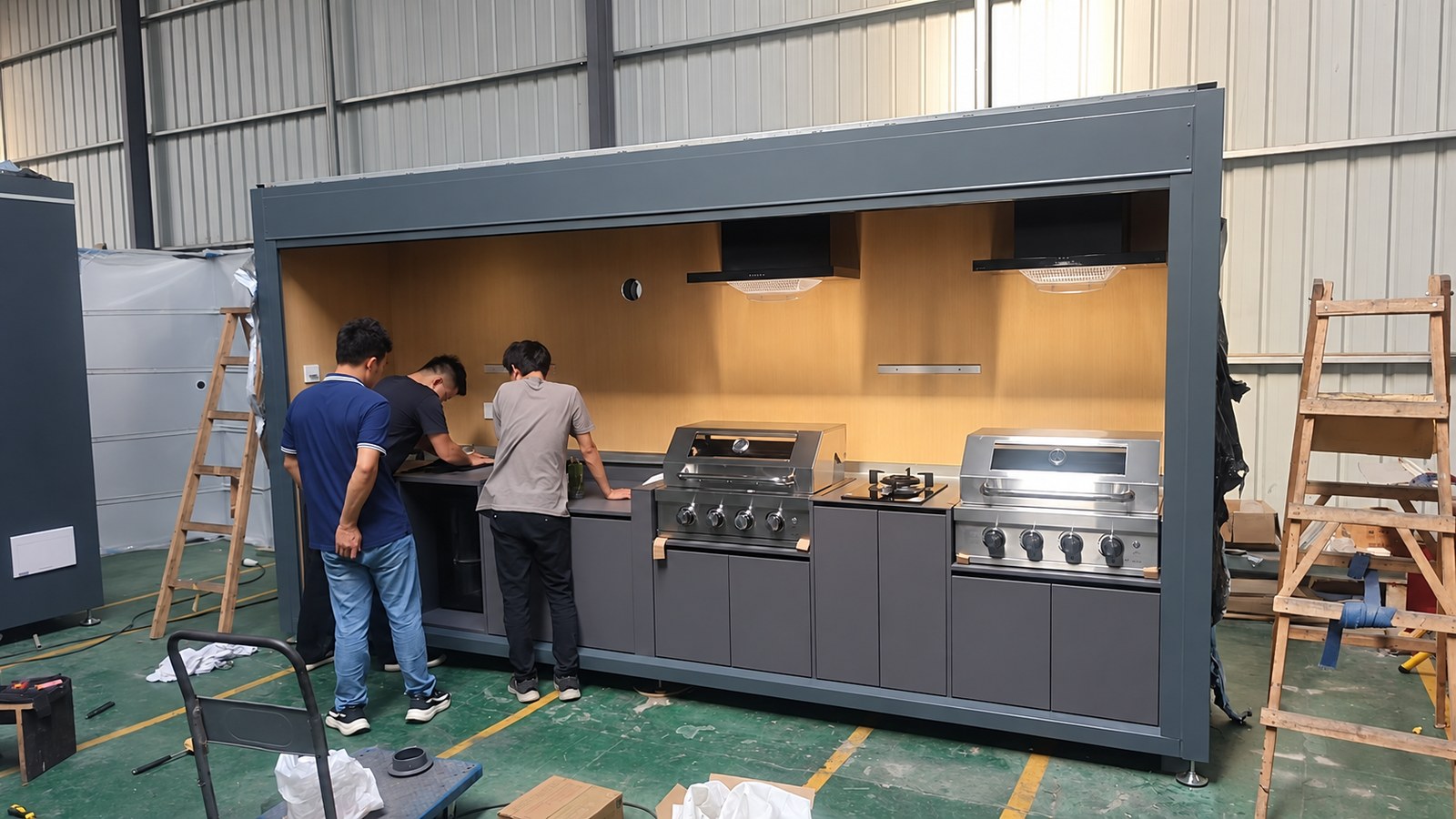 Production team checking cabinetry and equipment fit-out on an outdoor kitchen